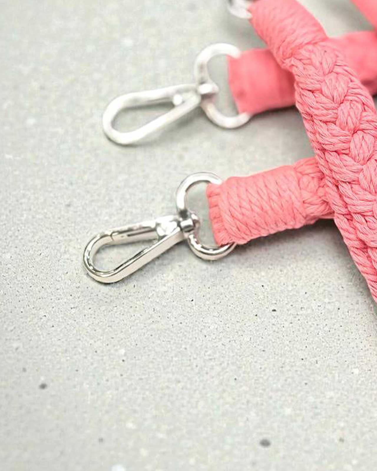 Silberfarbener Karabiner am rosa geflochtenen Schlüsselanhänger