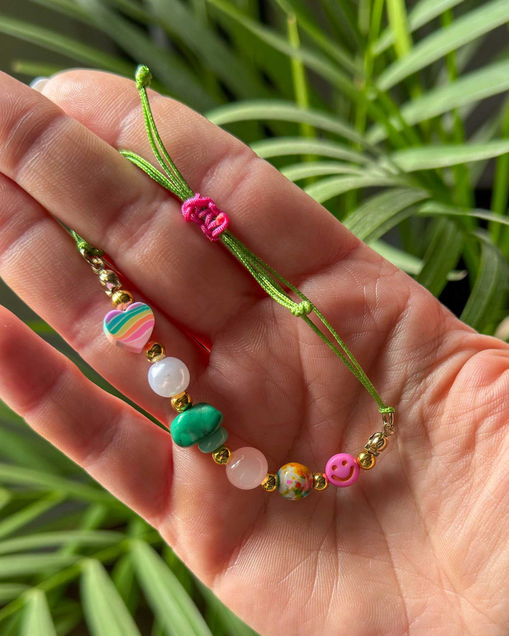 Handgefertigtes Perlenarmband mit Rosenquarz, Herzperle und Smile-Element aus der Liebeslicht Happy Heart Edition auf Schmuckkarte