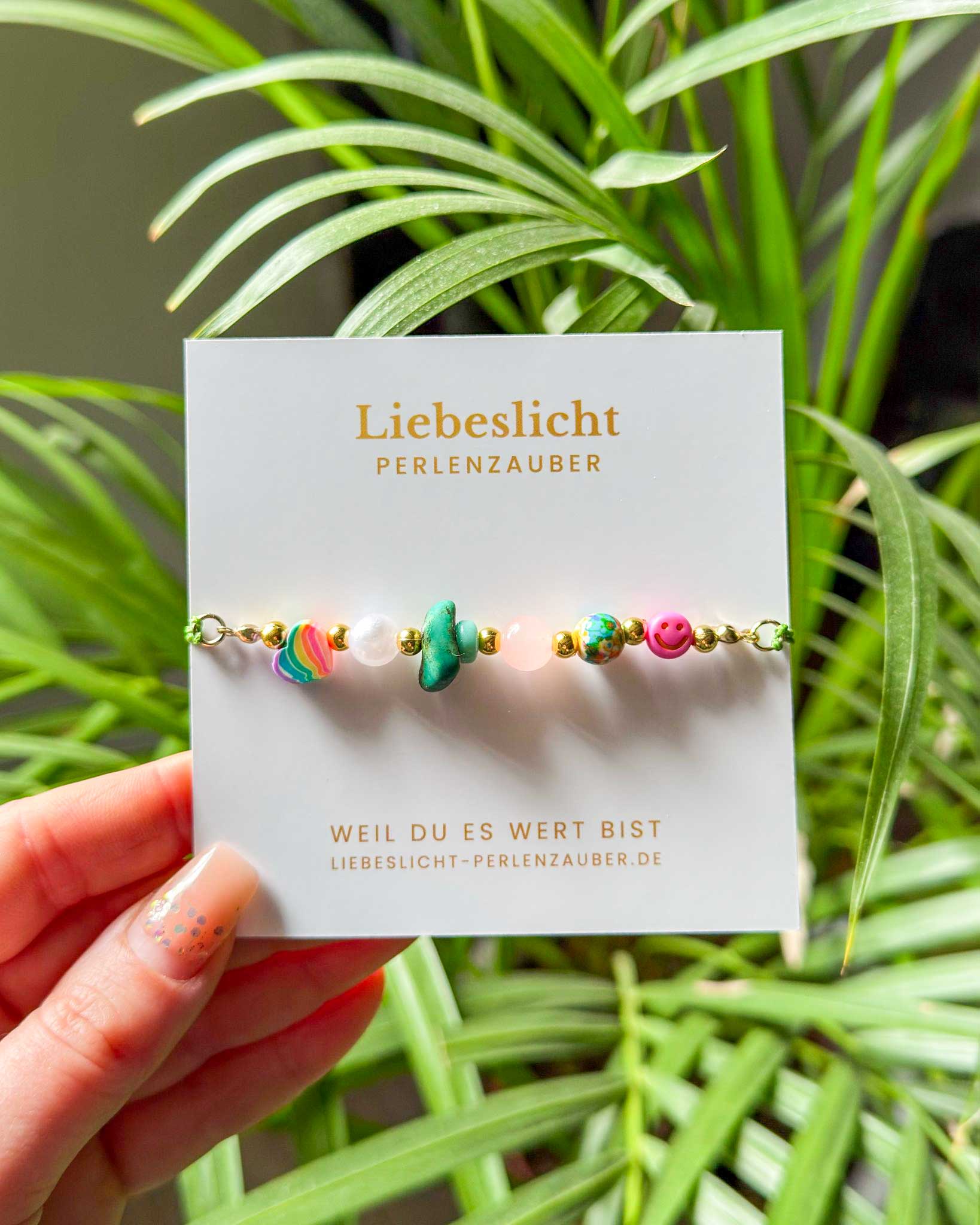 Detailaufnahme Perlenarmband mit Rosenquarz, Herzperle und Naturstein in der Hand – Liebeslicht Handmade Schmuck